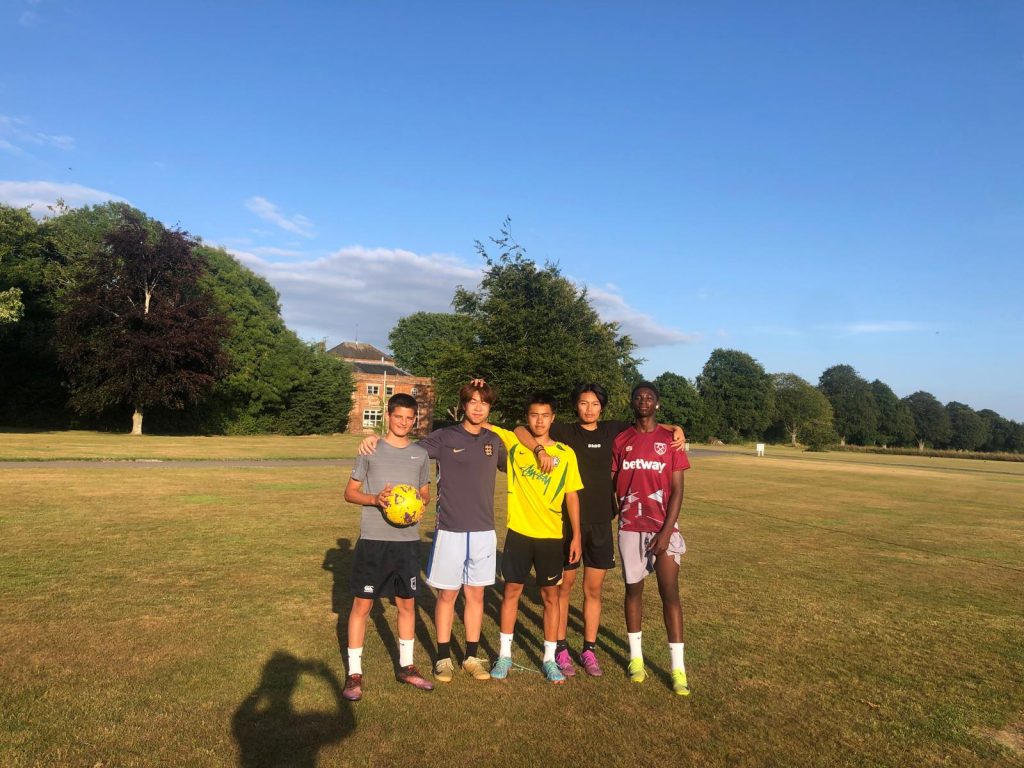 A group of five male Langley boarders outside on a sunny day on the Langley grounds